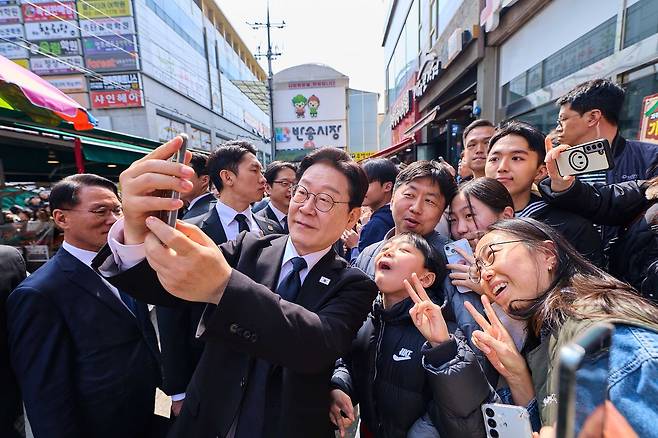 이재명 대통령이 15일 경남 창원시 반송시장을 방문해 주민들과 사진을 찍고 있다. 사진 청와대