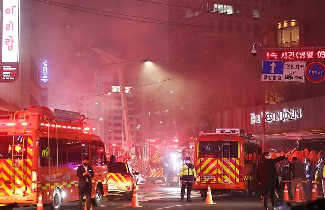 지난 14일 오후 서울 중구 소공동의 한 건물에서 불이나 소방대원들이 진화 작업을 벌이고 있다. 연합뉴스