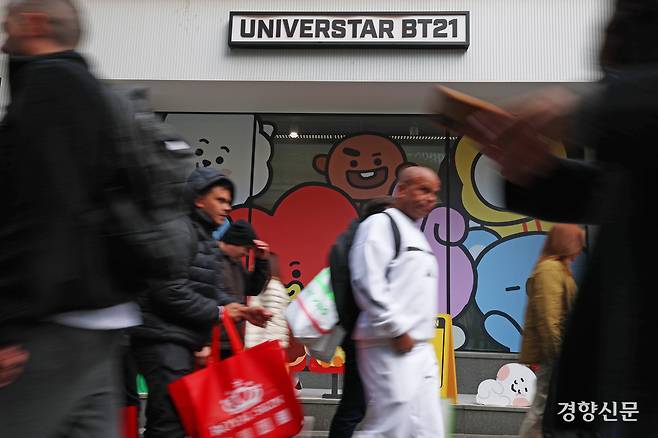 15일 서울 중구 명동의 관광객들이 BTS 캐릭터 상품을 파는 상점 앞을 지나고 있다.
