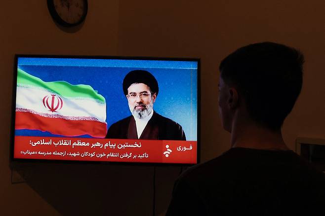 A man watches a televised statement by Iran's new supreme leader Mojtaba Khamenei on March 12. Ayatollah Mojtaba Khamenei, who was reportedly injured in an air strike, has yet to appear publicly since his nomination as supreme leader, and his defiant message was read by a newscaster on state television. [AFP/YONHAP]