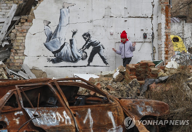 우크라이나가 우표로 발행한 뱅크시의 ‘푸틴 엎어치기’ 벽화. 해당 벽화는 우크라이나의 파괴된 건물에 그려졌다. [EPA연합뉴스]