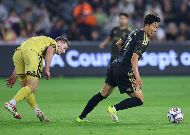 로스앤젤레스 FC의 공격수 손흥민(등번호 7번)이 세인트루이스 시티 SC의 미드필더 크리스 더킨(등번호 8번)으로부터 패스를 받아 드리블하고 있다. 게티이미지