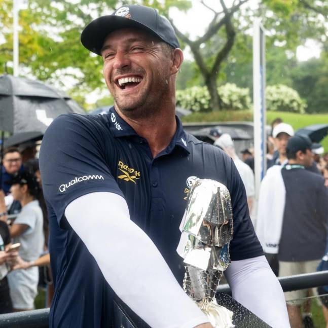 디섐보가 리브(LIV) 골프 싱가포르 우승 후 트로피를 품에 안고 환하게 웃고 있다. /사진=LIV 골프 공식 SNS