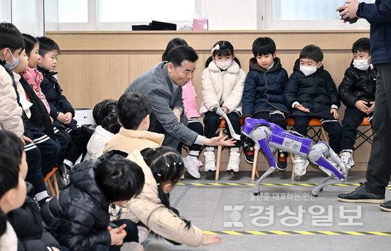 ▲ 2026년 상반기 로봇배움터 개강 수업이 지난 13일 울산중구로봇배움터에서 열린 가운데 김영길 중구청장과 지역 유치원 원생들이 피지컬 AI기술이 접목된 로봇개를 지켜보고 있다. 김도현기자 do@ksilbo.co.kr