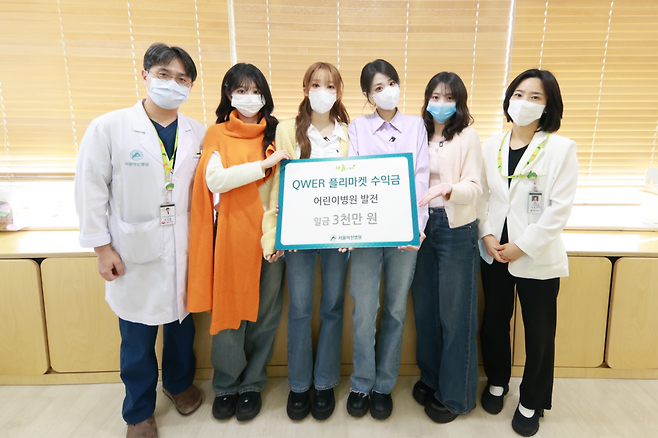 강성한 서울아산병원 소아청소년종양혈액과 교수(왼쪽)를 비롯한 의료진이 QWER과 기념촬영을 하고 있다.(사진제공=서울아산병원)