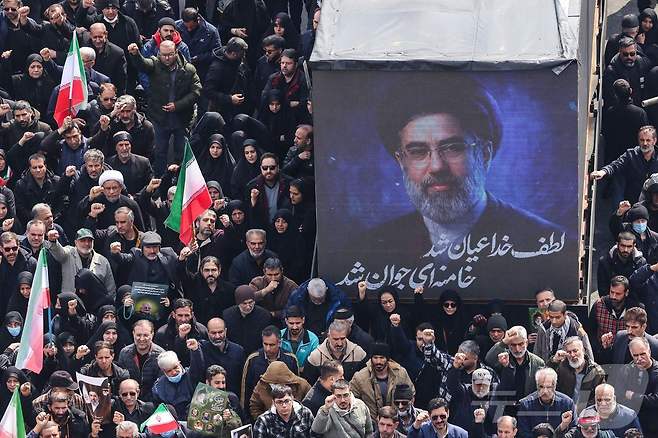 지난 11일(현지시간) 이란 테헤란 엔겔라브 광장에서 열린 이란 혁명수비대(IRGC) 지휘관 등의 장례식에서 이란의 새 최고지도자 모즈타바 하메네이의 초상화가 화면에 표시되고 있다. 2026.03.12. ⓒ AFP=뉴스1