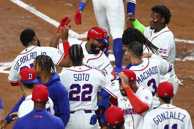 도미니카공화국의 주니어 카미네로가 선제 솔로포를 친 뒤 동료들의 축하를 받고 있다. AFP 연합뉴스,