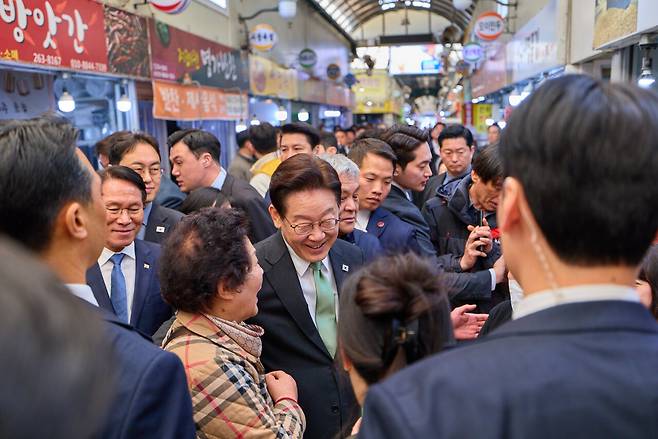 이재명 대통령이 지난 13일 충북 청주시 서원구 사창시장을 찾아 상인 및 시민들과 인사를 하고 있다. 연합뉴스