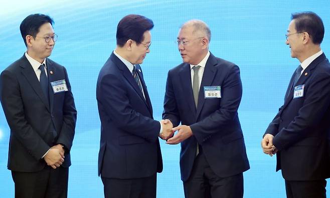이재명 대통령이 지난 2월 27일 전북 군산 새만금컨벤션센터에서 열린 '새만금 로봇·수소·AI시티 투자협약식'에서 기념촬영을 마친 뒤 정의선 현대자동차그룹 회장과 악수하고 있다. 사진=뉴시스
