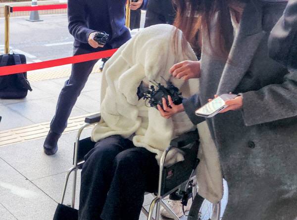 약에 취한 상태로 차량을 몰고 반포대교를 달리다 한강 둔치로 추락한 운전자 A 씨가 지난달 27일 서울 서부지방법원에서 열린 구속 전 피의자 심문(영장실질심사)에 옷으로 얼굴을 가리고 휠체어를 탄 채 출석하고 있다. 연합뉴스