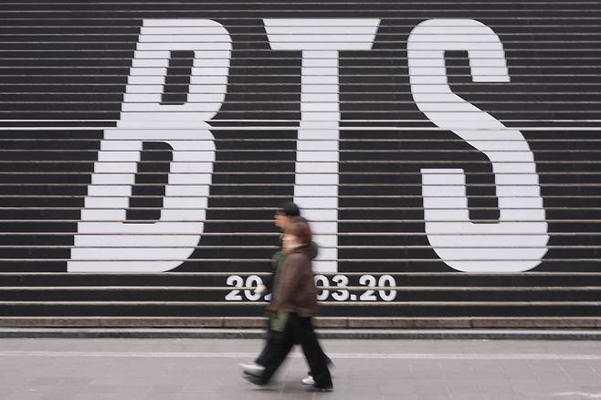 People walk by the huge letters of BTS in central Seoul on Jan. 15. [AP/YONHAP]