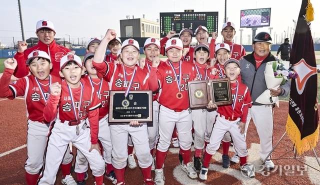 16일 오후 화성특례시 화성드림파크야구장에서 열린 ‘제9회 화성특례시장기 전국리틀야구대회’ 왕중왕전에서 우승을 차지한 서울 송파구리틀야구단 감독과 선수들이 우승컵을 들고 환호하고 있다. 홍기웅기자