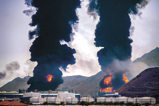 14일(현지시간) 이란 드론 공격을 받은 아랍에미리트(UAE) 푸자이라 항구의 석유 저장 시설에서 검은 연기가 치솟고 있다.  [ AFP연합뉴스]