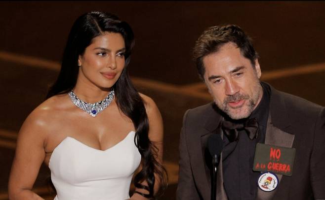 15일(현지시간) 미국 캘리포니아주 로스앤젤레스(LA) 할리우드에서 열린 제98회 아카데미 시상식에서 배우 하비에르 바르뎀(오른쪽)이 '전쟁을 멈춰라'(NO A LA GUERRA)라는 스페인어 문구를 가슴에 착용하고 배우 프리양카 초프라와 함께 무대에 올라 발언하고 있다/로이터=뉴스1