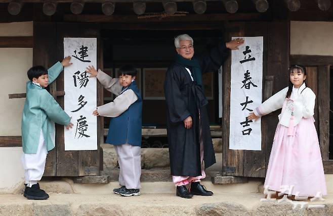 절기상 입춘(立春)인 2월 4일 오전 서울 종로구 국립민속박물관 내 오촌댁 대문에 서예가와 어린이들이 입춘첩을 붙이고 있다. 류영주 기자