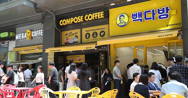 서울 시내에 위치한 저가 브랜드 커피 매장 앞에서 시민들이 줄지어 커피를 구매하고 있다. 뉴스1