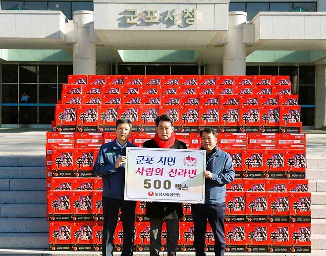 ▲ ㈜농심 안양공장이 펼치는 기업이윤의 지역사회 환원활동은 매년 이어지고 있다. 지난 연말 농심이 지역사회를 위한 나눔의 실천으로 신라면 500박스를 하은호 군포시장(가운데)에게 기탁했다. /사진제공=군포시청