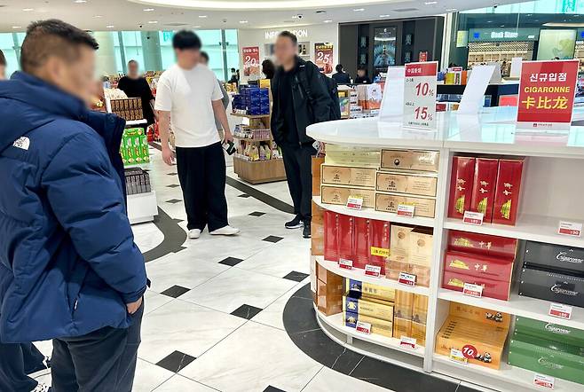 ▲&nbsp;지난달 22일 오전 10시30분쯤 인천국제공항 제2여객터미널 면세점에서 한 중국인이 중국산 수입 담배가 진열된 매대를 살펴보고 있다. /인천일보DB