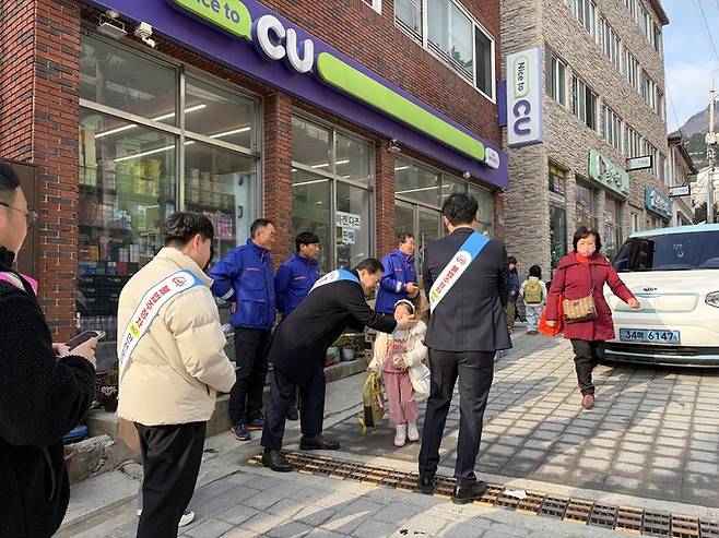 ▲ 울릉경찰서와 녹색어머니회 등 유관기관 캠페인 참가자들이 등굣길 학생들에게 유괴 예방을 비롯한 생활 속 안전수칙이 담긴 리플릿과 간식을 배부하고 있다. 사진 울릉교육지원청 제공