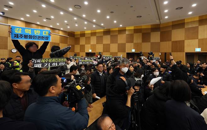 지난해 12월10일 제주시 봉개동 제주4·3평화교육센터에서 열린 제주평화인권헌장 선포식 행사장에서 인권헌장 선포에 반대하는 단체 관계자들이 손팻말을 들고 고성을 지르며 반발하고 있다. 연합뉴스