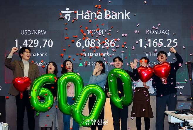 코스피가 6000포인트를 넘겼던 지난 25일 서울 중구 하나은행 본점 딜링룸에서 직원들이 세리머니를 펼치고 있다.  이준헌 기자