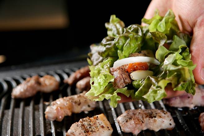 삼겹살을 구울 때 상추·양파·마늘 등 채소를 함께 섭취하면 조리 과정에서 생성될 수 있는 발암물질 노출 부담을 줄이는 데 도움이 될 수 있다. 게티이미지
