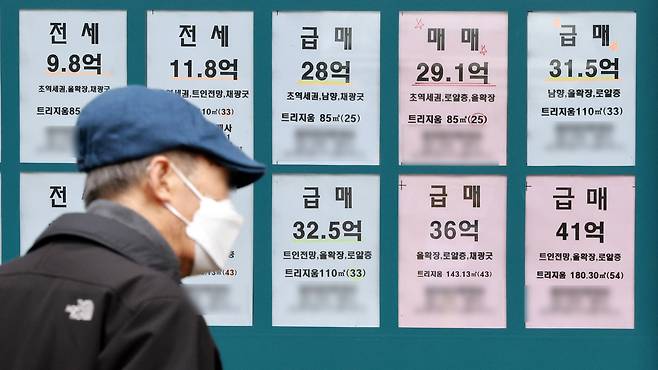 급매물이 게시된 서울의 한 부동산 중개업소 앞을 한 시민이 지나고 있다. 뉴스1