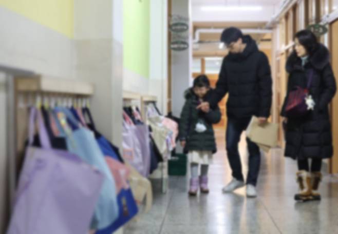 서울 한 초등학교에서 열린 신입생 예비소집에서 한 예비 초등학생과 부모님이 교내를 둘러보고 있다. 연합뉴스(해당 기사와 관련 없음)
