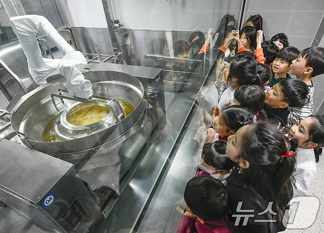 18일 경기 수원시 장안구 대평초등학교 내 위치한 거점형 학교급식 튀김 지원실에서 1학년 학생들이 튀김 조리 로봇이 직접 가동되는 현장을 보고 있다. (공동취재) 2026.3.18 ⓒ 뉴스1 김영운 기자