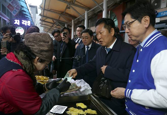 더불어민주당 정청래 대표가 18일 오전 경남 하동군 진교면 진교공설시장을 찾아 명태전을 구매하고 있다. 오른쪽은 김경수 경남지사 후보./연합뉴스