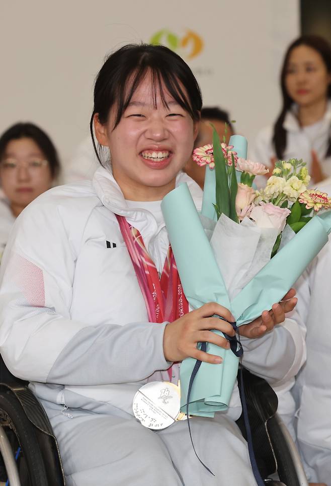 <yonhap photo-4166="">17일 인천국제공항 2터미널에서 열린 밀라노·코르티나담페초 동계 패럴림픽 한국 선수단 입국 환영ㆍ해단식에서 김윤지가 환하게 미소 짓고 있다. [사진=연합뉴스]</yonhap>