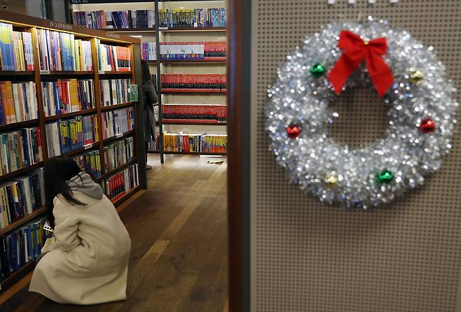 A Christmas wreath is attached on a bookshelf at a bookshop in Seoul in December 2025. [YONHAP]