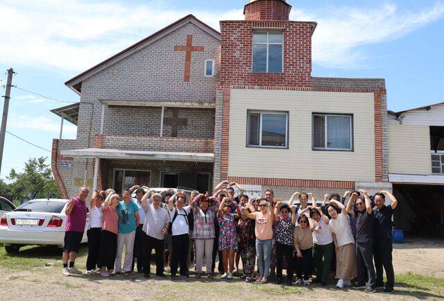 한국에서 온 단기 선교팀원들이 지난해 10월 러시아 라지돌리나의 동북아연해주신학교 앞에서 머리 위로 하트를 그리는 모습. 국제사랑재단 제공