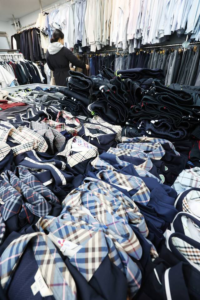 최근 서울 내 중고교 교복가격이 60만 원대까지 치솟은 가운데, 지난달 26일 서울 송파구 나눔교복매장을 찾은 학부모가 교복을 고르고 있다.  연합뉴스