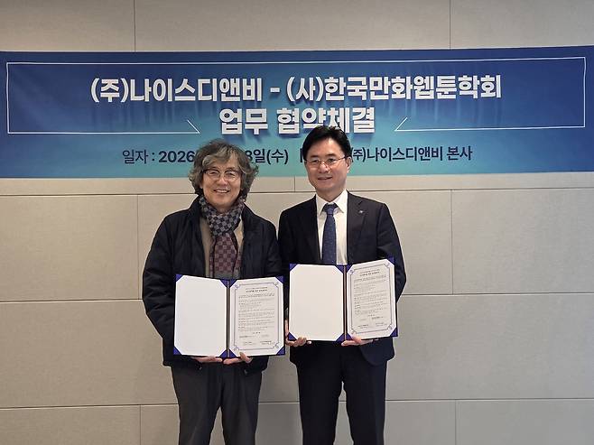 오규근 나이스디앤비 대표이사(오른쪽)는 18일 서울 본사에서 윤기헌 한국만화웹툰학회장과 웹툰 분야 인재양성·일자리 연계 및 콘텐츠 창업 생태계 지원을 위한 업무협약을 체결했다. (나이스디앤비 제공)