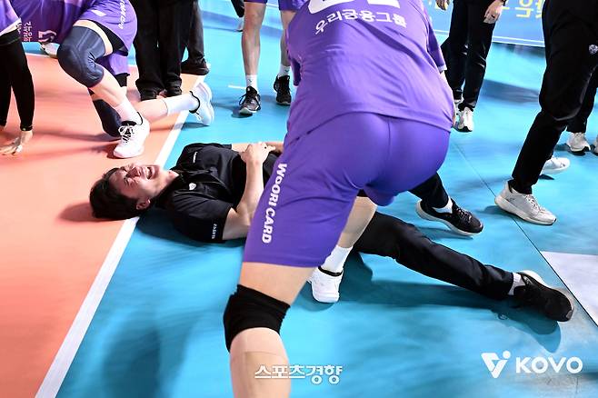 박철우 우리카드 감독대행(아래)이 17일 대전 충무체육관에서 열린 삼성화재와 2025~2026시즌 정규리그 최종전에서 승리하며 ‘봄 배구’ 진출을 확정한 뒤 선수들의 짓궂은 세리머니에도 코트에 누워 환하게 웃고 있다. KOVO 제공