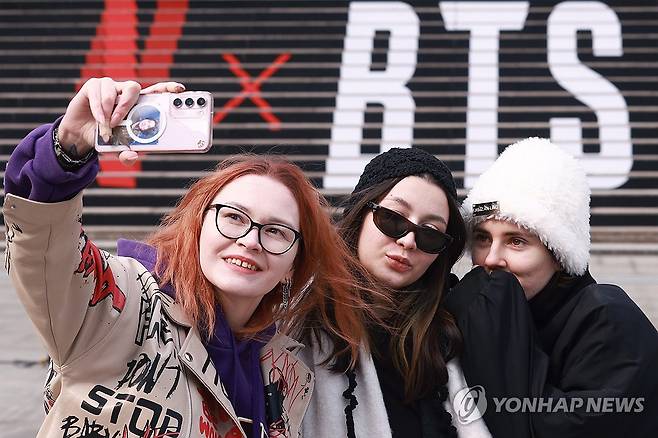 서울 종로구 세종문화회관 계단에서 방탄소년단(BTS) 공연 홍보물을 배경으로 기념촬영을 하는 관광객들 [연합뉴스 자료사진. 재판매 및 DB 금지]