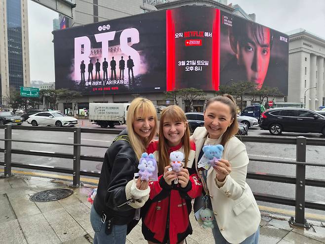 18일 오후 브라질에서 온 아나 판카(15)씨 가족이 명동 신세계백화점 본점 앞 전광판에서 송출되는 BTS 컴백 광고 앞에서 BTS 캐릭터 인형을 들고 사진을 찍고 있다./지혜진 기자