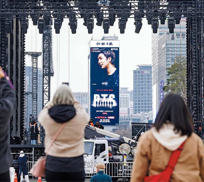 그룹 ‘방탄소년단(BTS)’의 컴백 공연을 사흘 앞둔 18일, 서울 광화문광장에 대형 무대가 들어섰다. 사진은 무대 뒤편인 경복궁 광화문 앞에서 바라본 모습이다. 코리아나호텔 전광판에 BTS 공연 홍보 영상이 나오고 있다. /장련성 기자