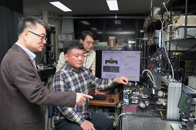 ETRI 연구진이 200Gbps 광검출기 소자의 성능측정 장비를 점검하고 있다.