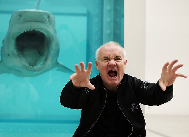 영국 작가 데이미언 허스트가 지난 18일 오전 서울 소격동 국립현대미술관에서 열린 개인전 ‘진실은 없어 그러나 모든 것은 가능하지’의 사전 언론 설명회에 나왔다. 상어 사체를 진열장 속에 넣은 대표작 ‘살아 있는 자의 마음속 죽음의 물리적 불가능성’ 앞에서 익살스러운 포즈를 취하고 있다. 연합뉴스