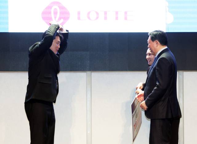 ▲ 한국 스노보드 국가대표팀 김상겸(왼쪽)이 19일 시그니엘 서울에서 열린 2026 밀라노-코르티나담페초 동계 올림픽 스키·스노보드 국가대표 선수단 격려 행사에서 신동빈 롯데그룹 회장의 특별 포상금을 받으며 하트를 그려보이고 있다. 연합뉴스