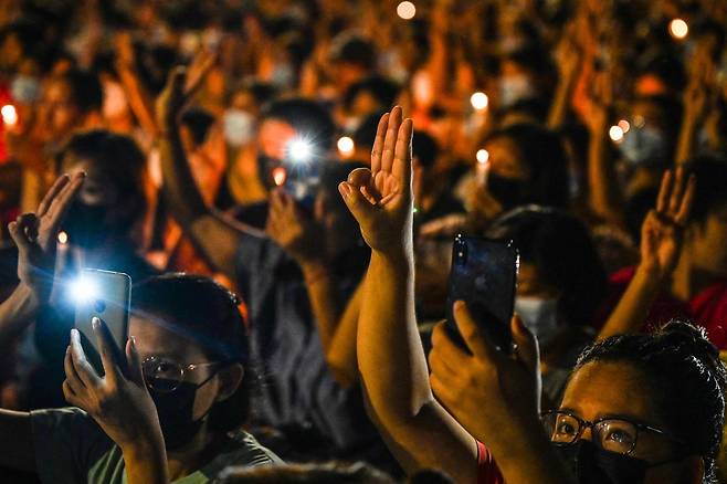 쿠데타 이후 반군부 시위가 열린 2021년 3월13일 미얀마 양곤에서 시위대가 군부와 싸우다 숨진 이들을 추모하기 위해 저항의 상징인 세 손가락을 들어보이고 있다. AFP연합뉴스