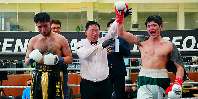 사단법인 한국복싱커미션 슈퍼미들급 챔피언 장민준이 2026년 3월 서울특별시 관악구민종합체육센터 특설 링에서 타이틀 1차 방어 성공 후 기뻐하고 있다. 왼쪽은 아쉬워하며 결과를 인정하는 도전자 김우진. 사진=KBM