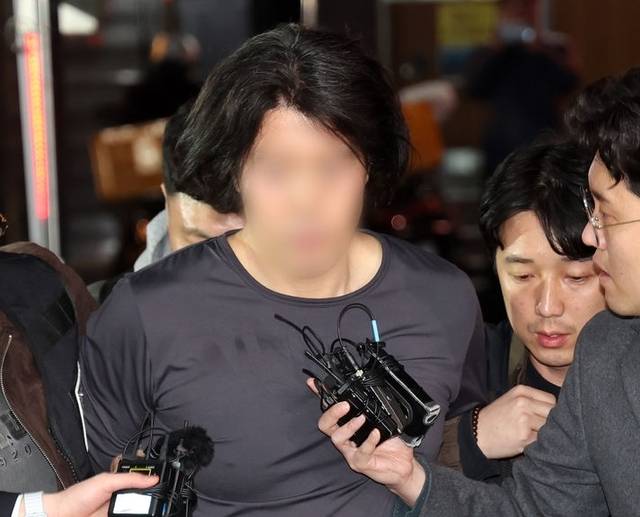 부산에서 전 직장 동료인 항공사 기장을 흉기로 살해한 혐의를 받는 50대 A씨가 17일 부산 부산진경찰서로 압송되고 있다.  뉴시스