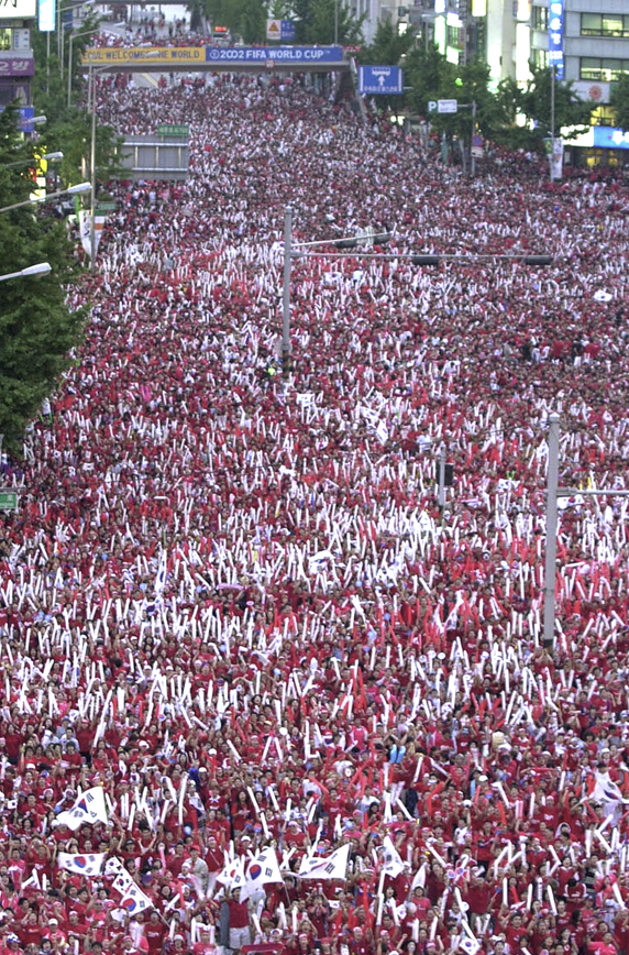 2002년 6월 14일 한일월드컵 조별리그 최종전에서 한국이 포르투갈을 1-0으로 꺾고 조 1위로 조별리그 통과를 확정하자 수많은 한국국민들이 거리에서 승리를 기뻐하며 축하하고 있다. 게티이미지