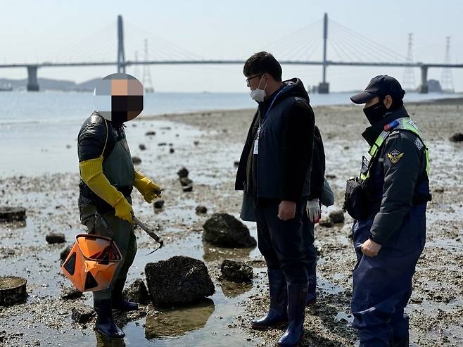 ▲ 20일 오전 인천 영흥면 갯벌에서 해루질 단속에 나선 해경과 특별사법경찰이 비어업인 채취 도구와 어획물을 확인하고 있다.