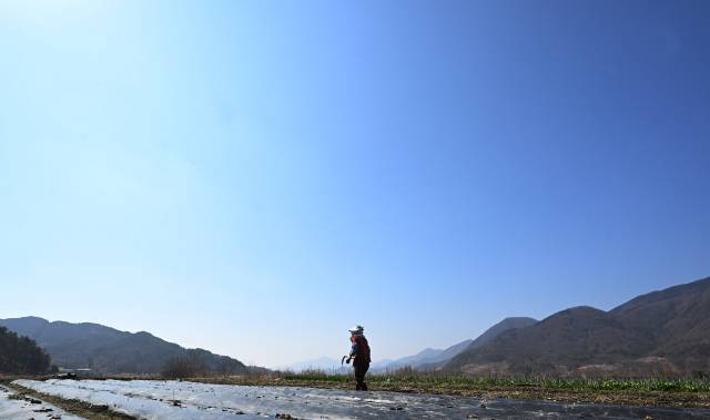 지난해 3월 21일 산청군 시천면에서 발생한 산불이 능선을 타고 단성면 자양리와 하동군 옥종군 두양리 경계 지점까지 번지는 것을 지켜본 주민이 1년 후인 19일 같은 장소에서 농사 준비를 하고 있다./김승권 기자/