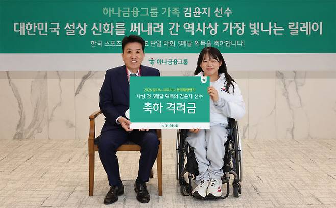 하나금융그룹은 지난 19일 하나금융그룹 명동 사옥에서 ‘2026 밀라노·코르티나 동계패럴림픽’ MVP로 선정된 김윤지 선수를 초청해 격려금을 전달하고, 임직원과 함께하는 사인회 행사를 개최했다. 이날 행사에 참석한 김윤지 선수(사진 오른쪽)와 함영주 하나금융그룹 회장이 기념 촬영을 하고 있다. 사진=하나금융 제공