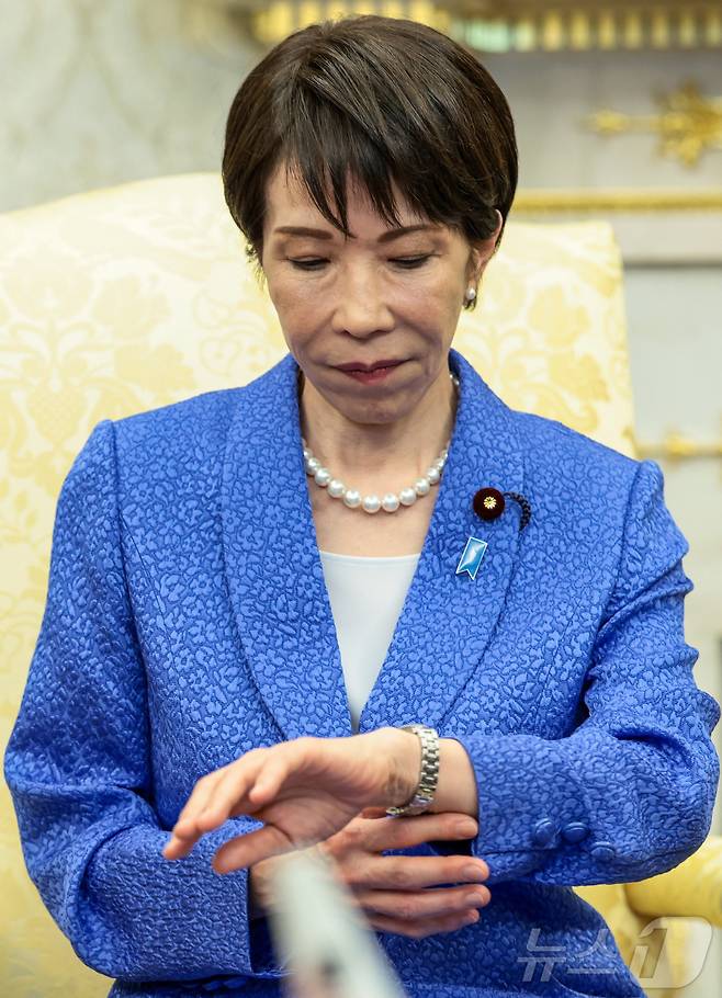 다카이치 사나에 일본 총리가 19일(현지시간) 워싱턴DC 백악관에서 도널드 트럼프 미국 대통령과의 정상회담 중 잠시 시계를 들여다보고 있다. 이날 다카이치 총리는 납북된 일본인 피해자에 대한 관심을 촉구하는 파란 리본 배지를 달고 미일 정상회담에 임해 눈길을 끌었다. 2026.03.19. ⓒ 로이터=뉴스1